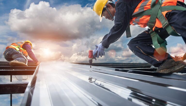 Metal roof benefits - two workers installing a metal roof